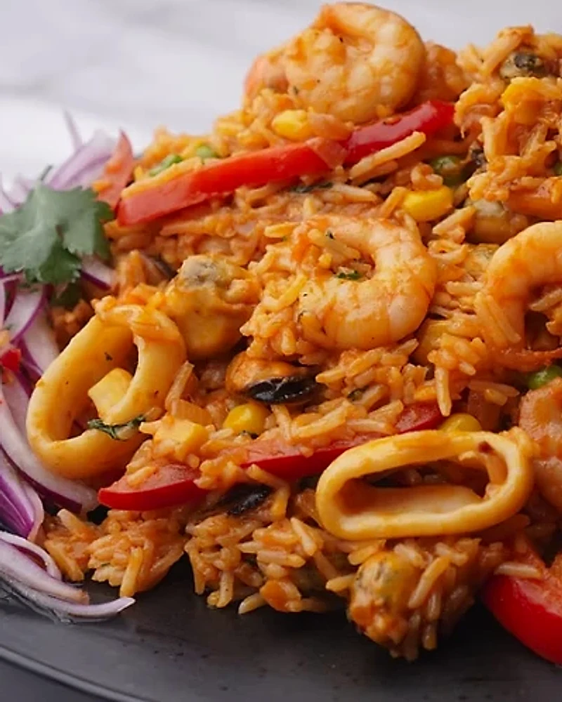 Arroz con mariscos con langostinos, calamar, pimiento y salsa criolla