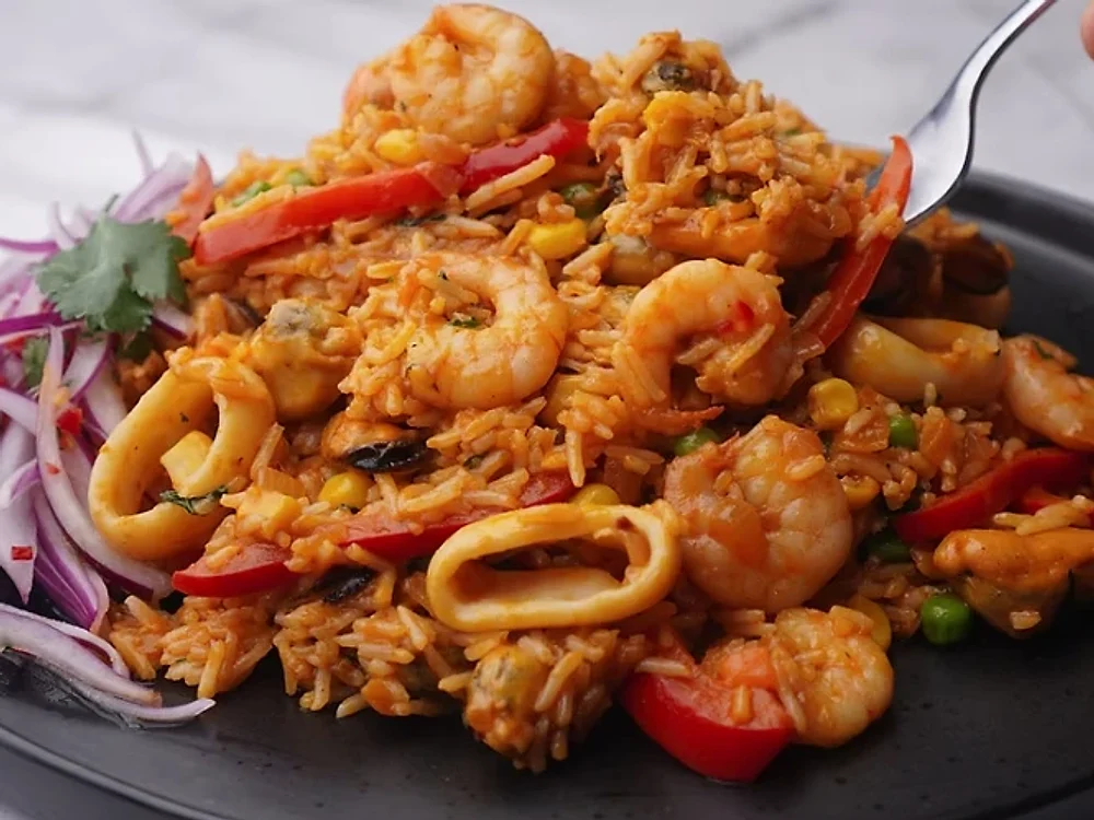 Arroz con mariscos con langostinos, calamar, pimiento y salsa criolla